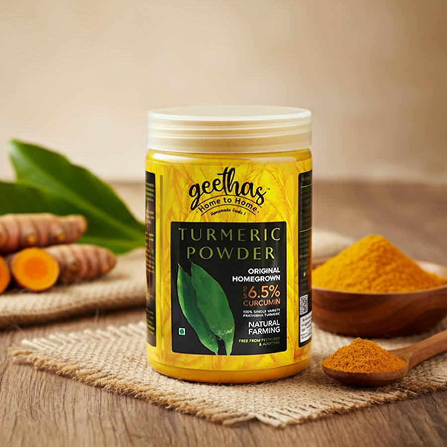 Jar of geethas Turmeric Powder with turmeric roots and powder on a wooden surface