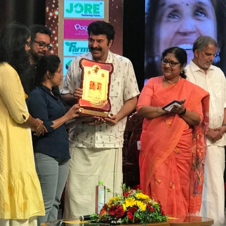 Geetha receiving the Kairali TV Phoenix Award for Best Women-Led Entrepreneur from Mammootty