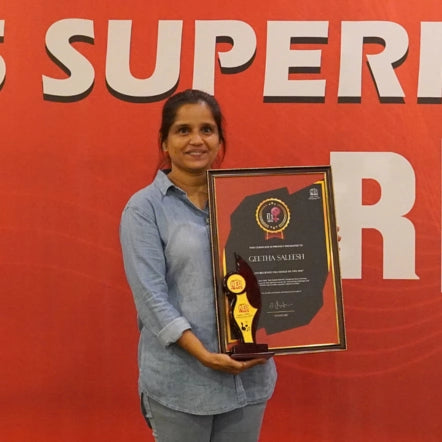 Geetha receiving a Red FM award, reflecting her strength and entrepreneurial journey