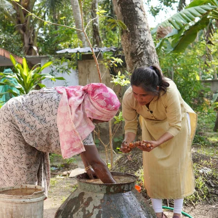 Geetha examining freshly washed turmeric roots